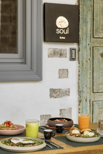 a table with plates of food and drinks on it at SYROS SOUL LUXURY SUITES in Ermoupoli