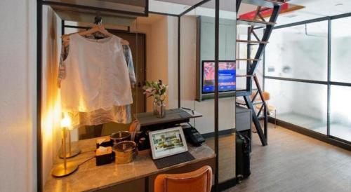 a room with a loft bed with a dress hanging on a shelf at Hotel Soloha @ Chinatown in Singapore