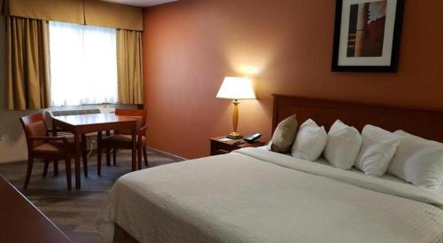 a hotel room with a bed and a dining table at Airport Inn in Boise