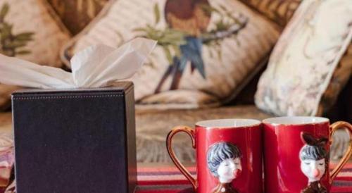 two red coffee mugs on a table next to a couch at Hangzhou The First World Hotel in Hangzhou