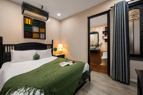 a bedroom with a bed and a mirror and a bathroom at Old Town Hotel in Hoi An