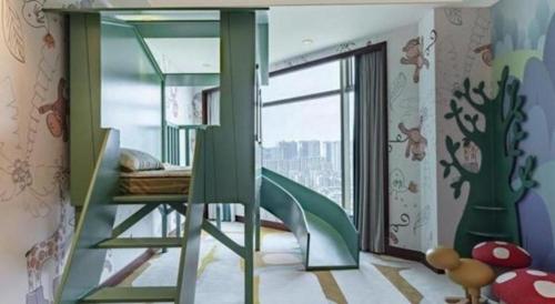 a childrens room with a green bunk bed and a window at New Century Grand Hotel Zhuji Yaojiang in Shaoxing
