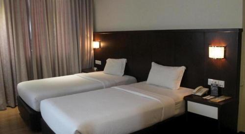 a hotel room with two beds and a telephone at The BCC Hotel & Residence in Nagoya