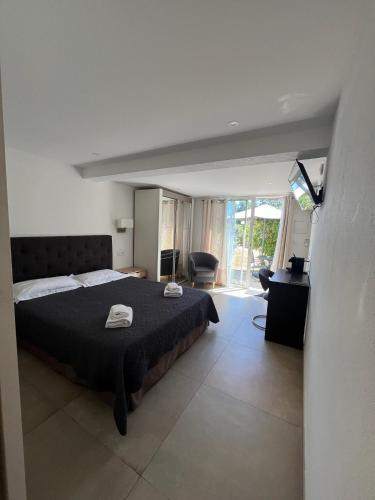 - une chambre avec un grand lit et une couverture noire dans l'établissement Résidence Les Cigales, à Porto-Vecchio