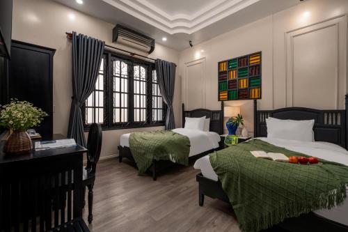 a hotel room with two beds and a desk at Old Town Hotel in Hoi An