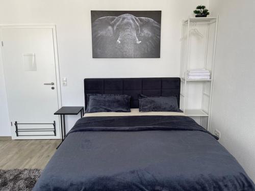a bedroom with a bed and a picture of an elephant at Cozy room 500 m to uni-Kassel in Kassel