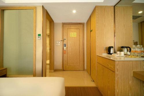 a kitchen with a door leading to a hallway at Vienna Hotel Harbin Central Avenue in Harbin