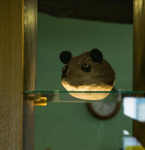 a cake in the shape of a teddy bear on a glass shelf at Hotel Garni Myší Díra in Český Krumlov