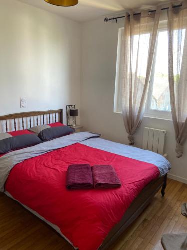 - une chambre avec un grand lit rouge et 2 serviettes dans l'établissement Centre à pied, à Bourges