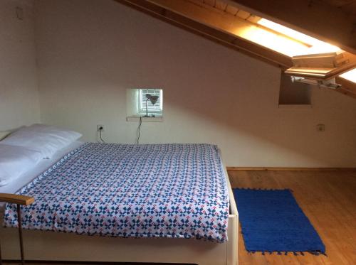 ein Schlafzimmer mit einem Bett und einem blauen Teppich in der Unterkunft Apartman Ustrine in Ustrine