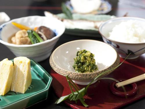 a table topped with bowls and plates of food at Suigetsurou Hotel in Takaoka