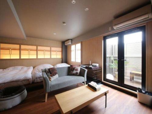 a bedroom with a bed and a chair and a table at Suigetsurou Hotel in Takaoka