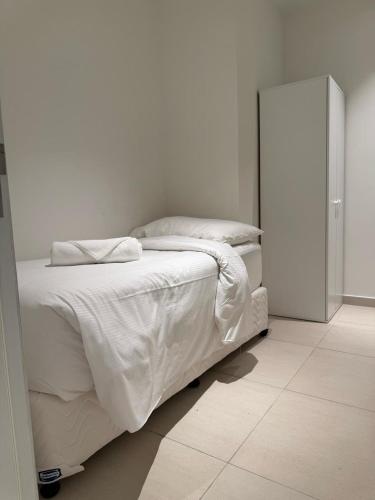 a bedroom with a bed with white sheets and pillows at Address Beach Resort Fujairah Apartment by Blue World - 2 in Fujairah