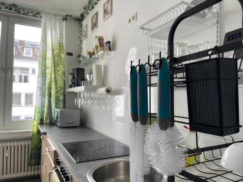 a kitchen with a sink with utensils on a rack at Friendly-room 200 m to 5 museums in Kassel