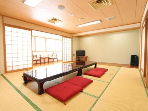 a room with a table and two red pillows at Hotel Livemax BUDGET Chitose in Sapporo