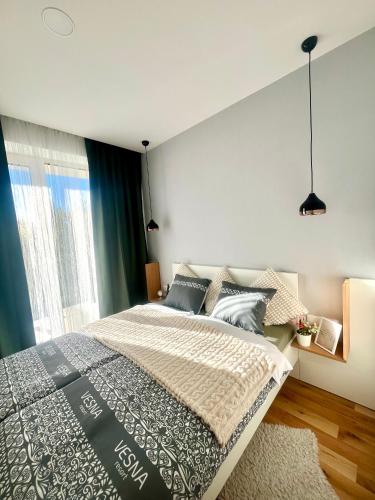 a bedroom with a large bed with blue curtains at Apartmán PLÁŇ Vesna Resort in Vysoké Tatry
