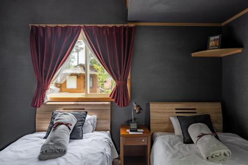 a bedroom with two beds and a window at DogrunCafe & Resorts JENNIE West-Karuizawa in Miyota