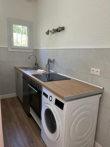 une cuisine avec une machine à laver et un évier dans l'établissement Résidence Les Cigales, à Porto-Vecchio