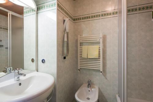 a bathroom with a sink and a shower at Hotel Rezia in La Villa