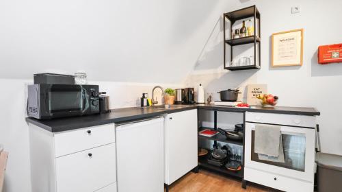 a kitchen with white cabinets and a microwave at Moderne Wohnung - Nähe Messe / Flughafen in Lohmar