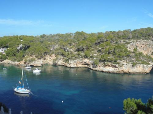 a sail boat in the water near an island at Hostal Can Jordi in Cala Figuera