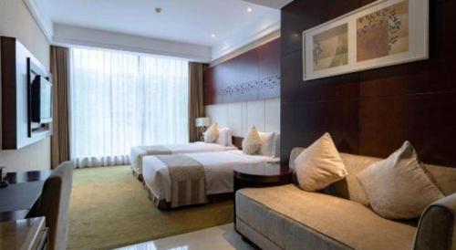 a hotel room with two beds and a couch at Suzhou Qingshan Conference Center in Suzhou