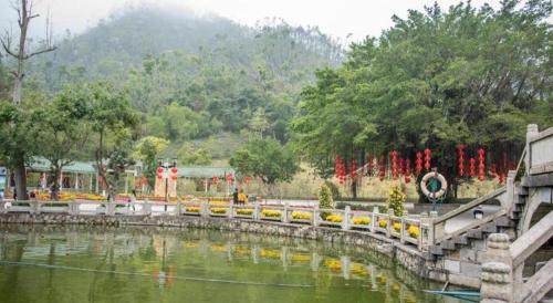 a bridge over a pond in a park at 7 Days Premium Zhuhai Gongbei Light Railway Branch in Zhuhai