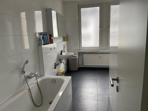 a white bathroom with a tub and a sink at Private room in city centre in Kassel