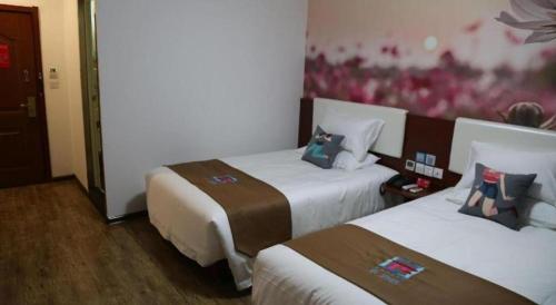 a hotel room with two beds and a painting on the wall at PAI Hotels·Shijiazhuang Development Zone Tianshan Science and Technology Park in Shijiazhuang