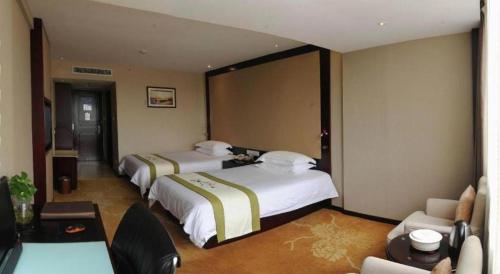 a hotel room with two beds and a couch at Quanzhou Overseas Chinese Hotel in Quanzhou