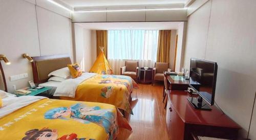 a hotel room with two beds and a flat screen tv at Quanzhou Overseas Chinese Hotel in Quanzhou