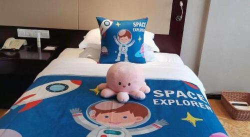a bed with a star wars pillow and a toy on it at Quanzhou Overseas Chinese Hotel in Quanzhou