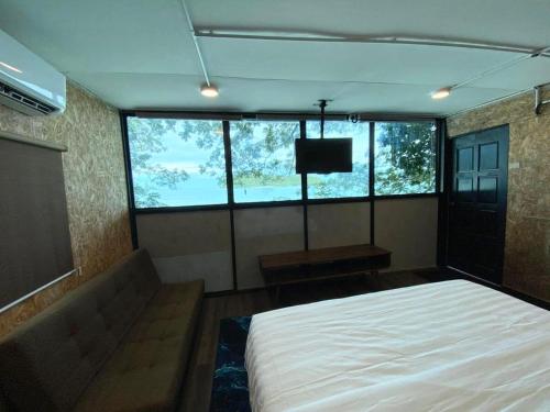 a bedroom with a bed and a flat screen tv at Cenanghill Beachfront in Pantai Cenang
