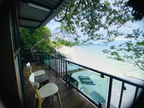 a balcony with two chairs and a view of the ocean at Cenanghill Beachfront in Pantai Cenang