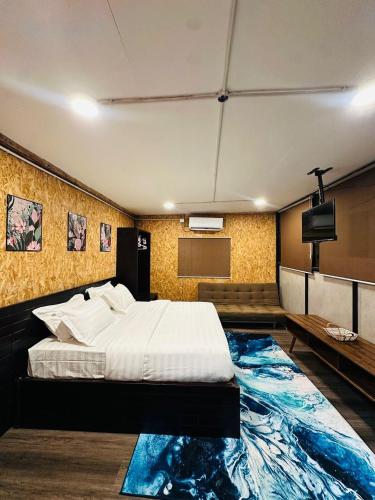 a bedroom with a bed and a flat screen tv at Cenanghill Beachfront in Pantai Cenang