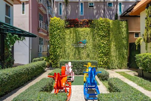 a garden with colorful toy trains in the grass at C202 Sun and Fun Kids Club 1BR 500m to Beach in Kata Beach