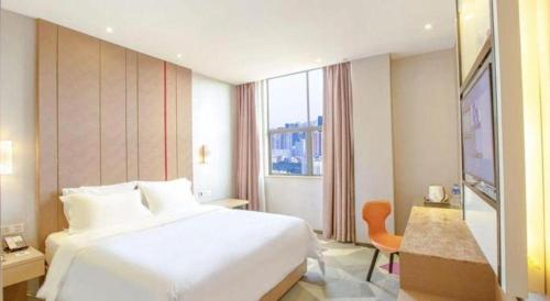 a hotel room with a white bed and a window at Shenzhen Lavande Hotel Airport Terminal Branch in Shenzhen