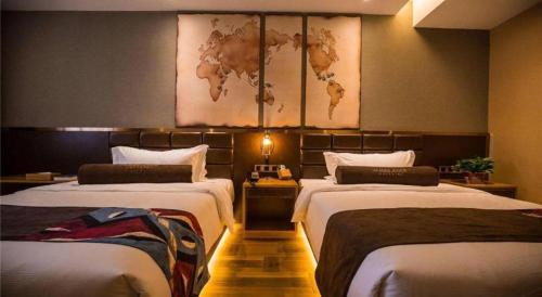 a hotel room with two beds and a map on the wall at James Joyce Coffetel·Kaifeng Drum Tower in Kaifeng