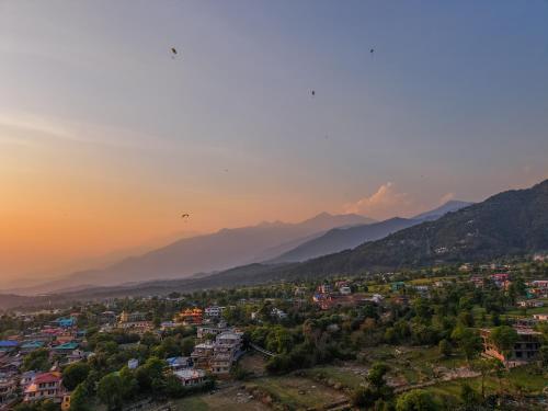 a view of a city with mountains in the background at Appas Hotel in Bīr