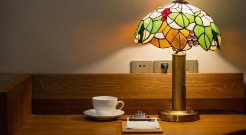a table with a lamp and a cup on it at James Joyce Coffetel·Lijiang Old Town Centeral in Lijiang