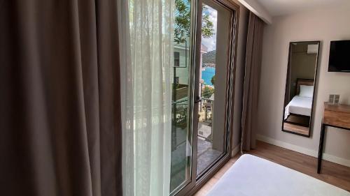 a room with a large window with a view of the ocean at Sahil Otel in Cesme