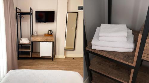 a bathroom with a pile of towels and a mirror at Sahil Otel in Cesme