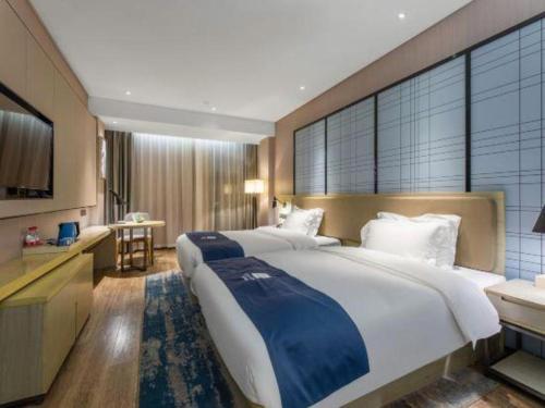 a large bedroom with a large bed and a kitchen at Echarm Hotel Xiangyang Erqi in Xiangyang