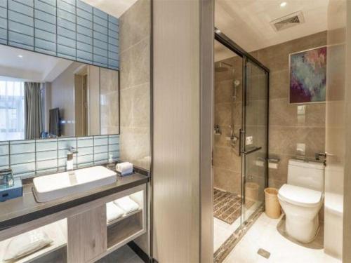 a bathroom with a toilet and a sink and a shower at Echarm Hotel Xiangyang Erqi in Xiangyang
