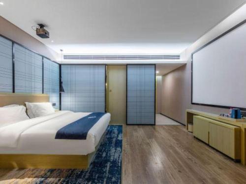 a bedroom with a bed and a projection screen at Echarm Hotel Xiangyang Erqi in Xiangyang