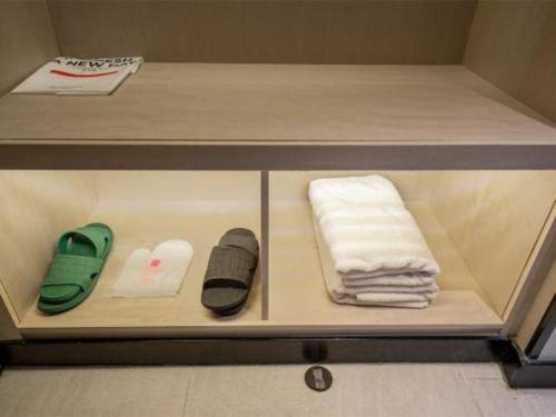 a shelf with towels and other items on it at Echarm Hotel Xiangyang Erqi in Xiangyang