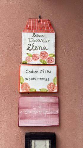 a sign on the side of a wall with tomatoes at Casa vacanze Elena in Rometta