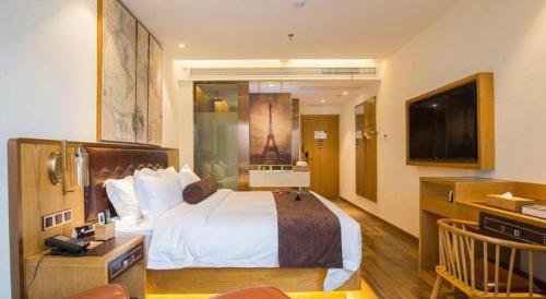 a hotel room with a bed and a television at James Joyce Coffetel· Hefei Anhui Agricultural University in Hefei