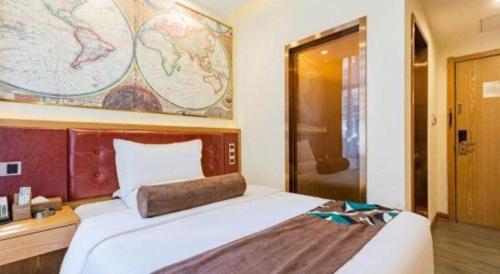 a bedroom with a large bed with a map on the wall at James Joyce Coffetel Harbin Central Street in Harbin