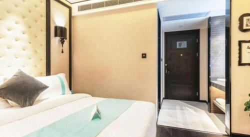 a bedroom with a bed and a large mirror at Xana Hotelle Zhuhai Gongbei Port in Zhuhai
